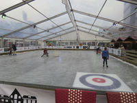 907386 Afbeelding van het interieur van de tijdelijke ijsbaan op de Neude te Utrecht, met enkele jeugdige schaatsers.